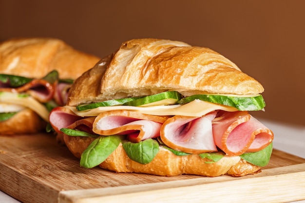 Croissants sandwiches on the wooden cutting board