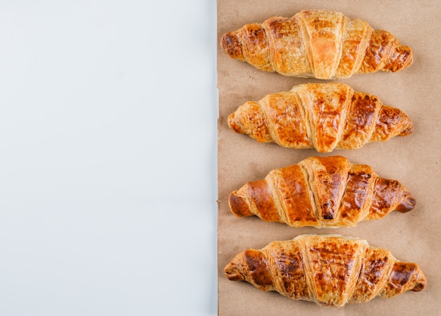 Free Photo croissants on white and paper bag, flat lay.