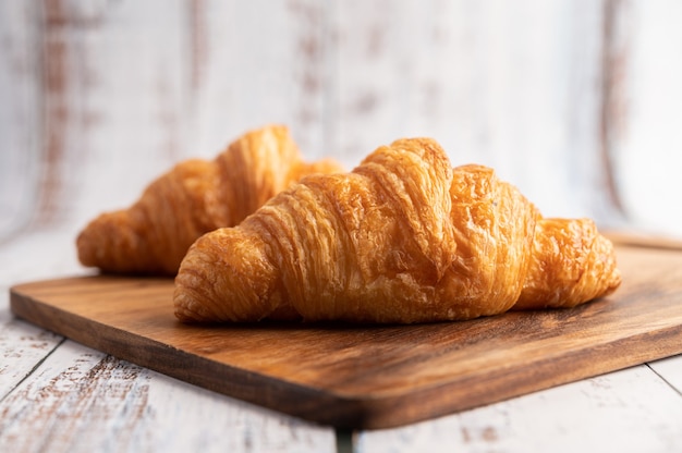 Croissants on a wooden cutting board.