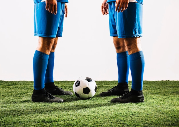 Crop athletes near soccer ball