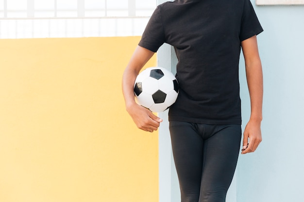 Free photo crop black man standing and holding football