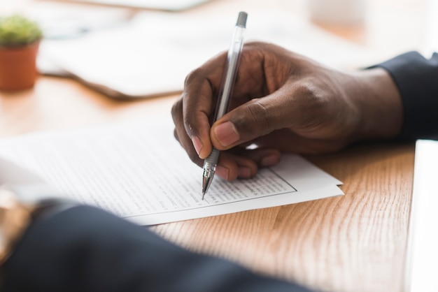 Crop businessman signing papers