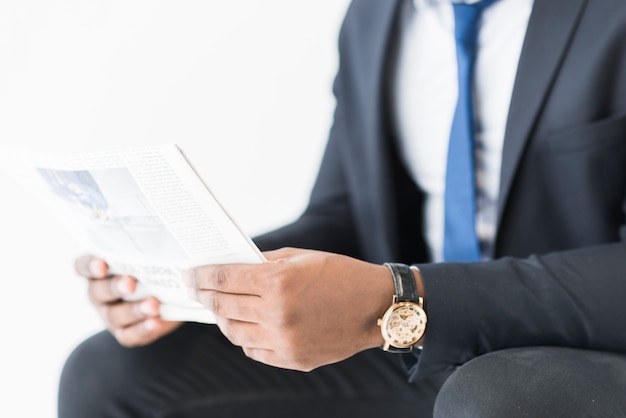 Crop businessman with newspaper