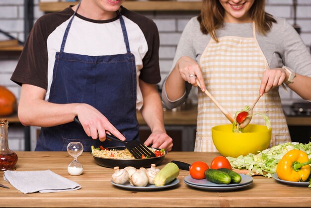 Crop couple mixing vegetables