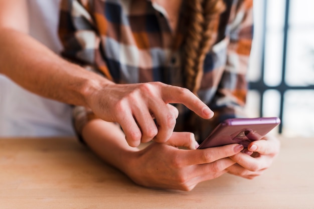 Crop couple using smartphone together 