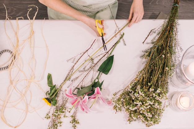 Free photo crop florist cutting flowers for bouquet