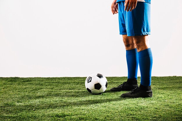 Crop football player near ball