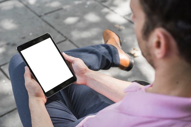 Crop guy using tablet on street