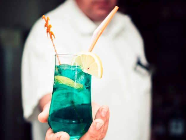 Free photo crop hand of anonymous bartender passing refreshing drink