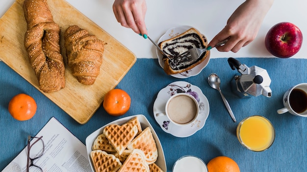 Free photo crop hand cutting pastry for breakfast