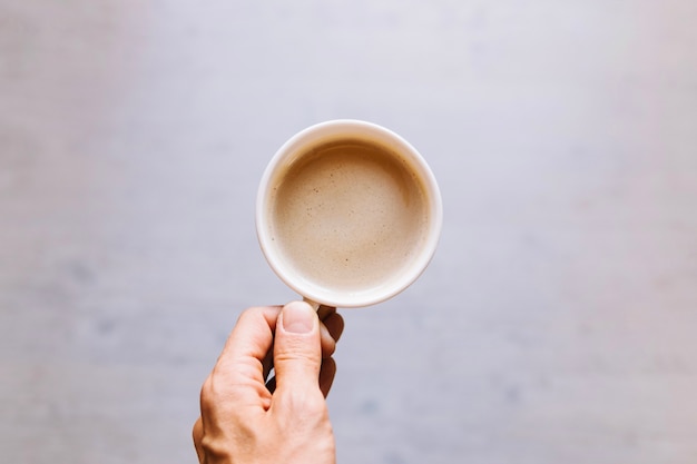 Free photo crop hand holding cup of coffee