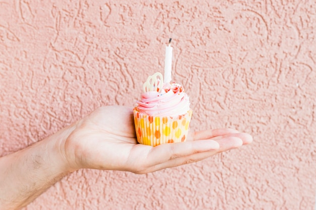 Free photo crop hand holding cupcake with candle