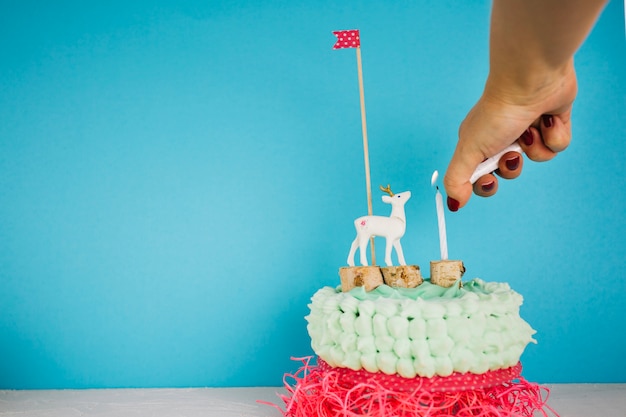 Free photo crop hand lighting candle on cake