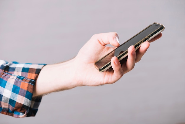 Crop hand of man with smartphone