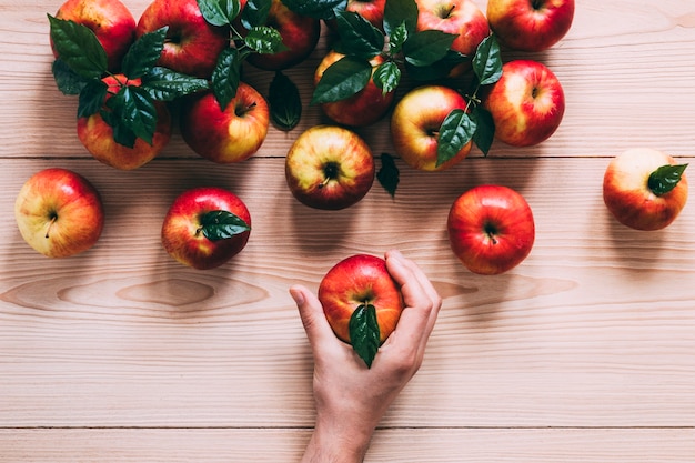 Crop hand taking apple from pile