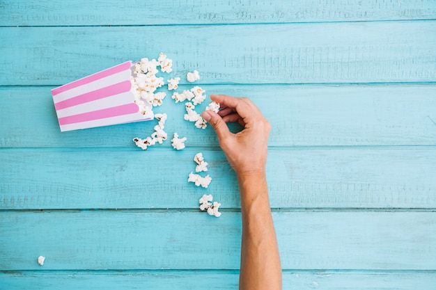 Free Photo crop hand taking popcorn from popcorn box