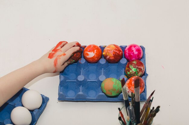 Free photo crop hand touching colored eggs