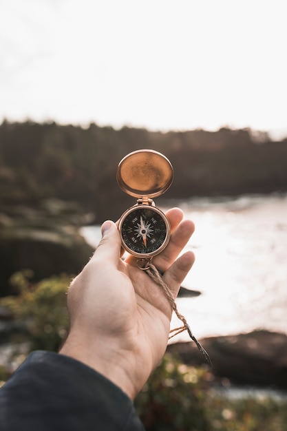 Free photo crop hand with compass in nature