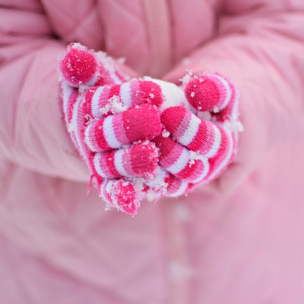 "Crop hands in gloves holding snowball"