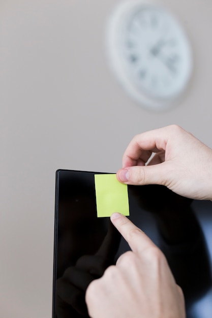 Free photo crop hands hanging note on monitor