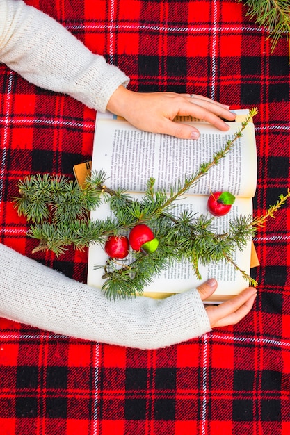 Free photo crop hands holding book on blanket