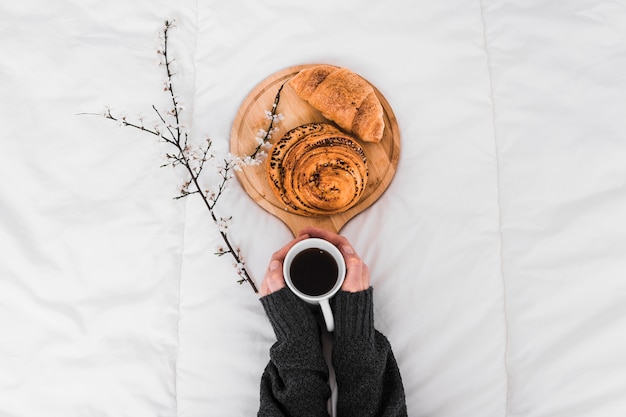 Free photo crop hands holding coffee near buns