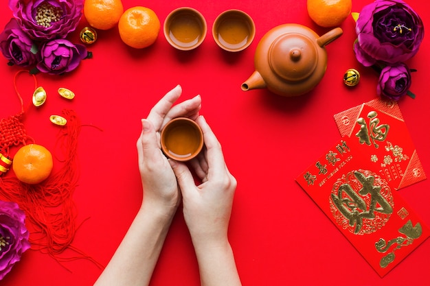 Free photo crop hands holding cup of tea