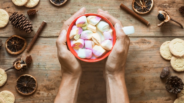 Free Photo crop hands holding hot chocolate near spices