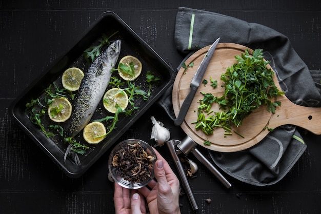 Free photo crop hands holding spices near fish