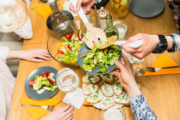 Free Photo crop hands putting delicious salad on plate