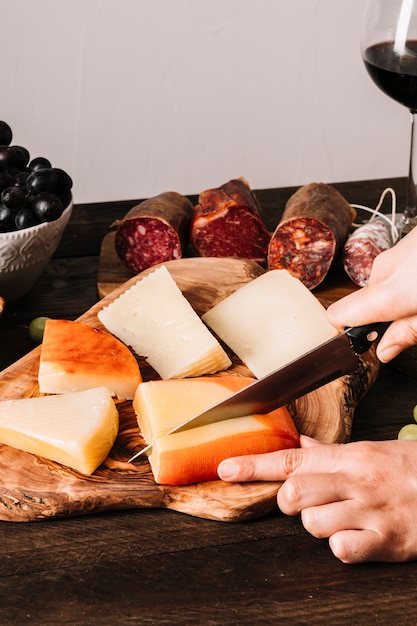 Free Photo crop hands slicing cheese