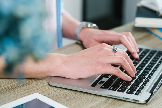 Crop hands using laptop in office