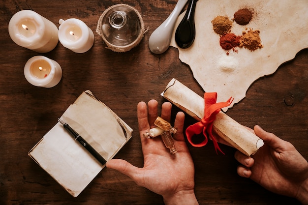 Crop hands with bottles and scroll