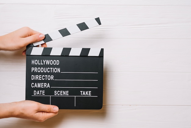 Free photo crop hands with opened clapperboard