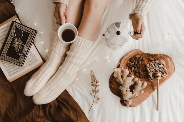 Free photo crop lady pouring coffee near books and snacks