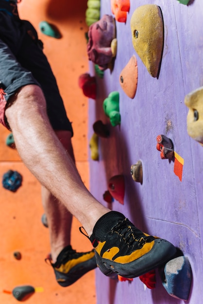 Crop legs climbing high wall