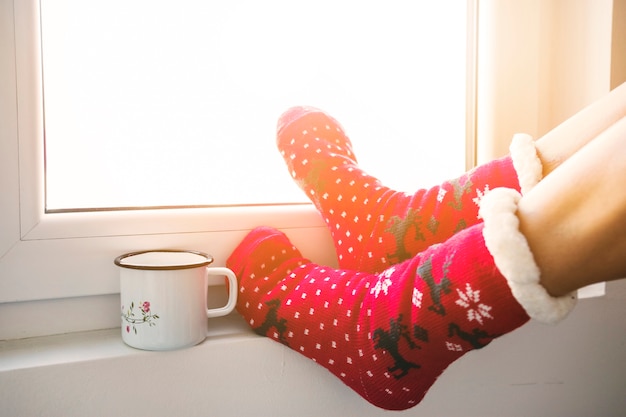 Free photo crop legs and mug near window