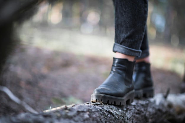 Crop legs walking on log