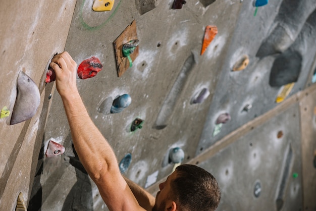 Free Photo crop man climbing high wall