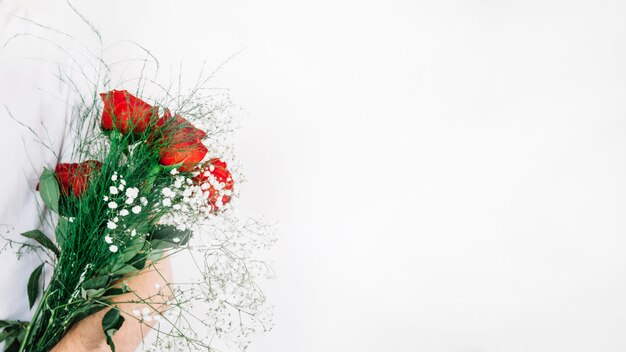 Crop man holding bouquet of roses