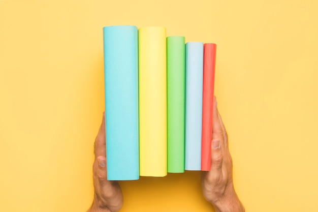 Free photo crop man holding ordered set of books