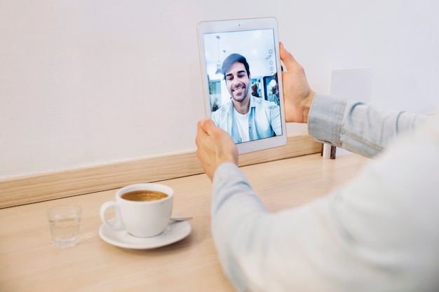 Crop man holding tablet with selfie