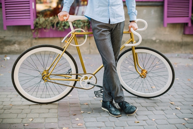 Free photo crop man leaning on bike