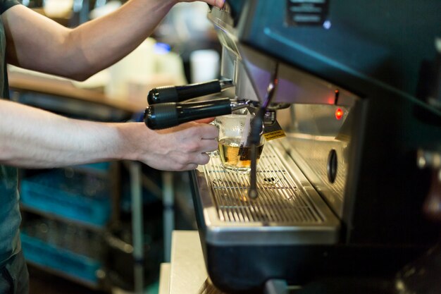 Crop man pouring hot water into cup