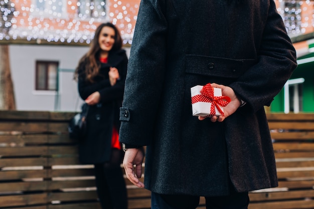 Crop man preparing gift box for woman