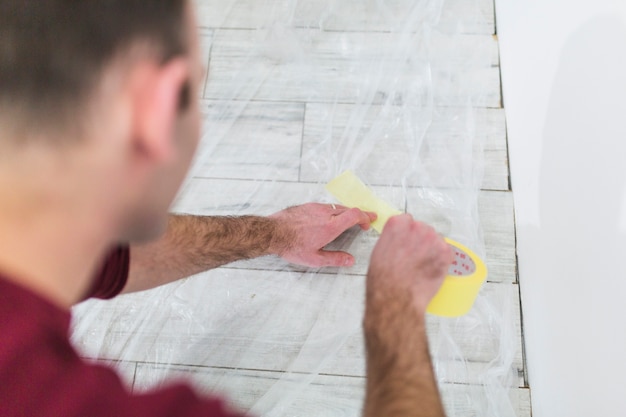 Free Photo crop man protecting floor with sheet