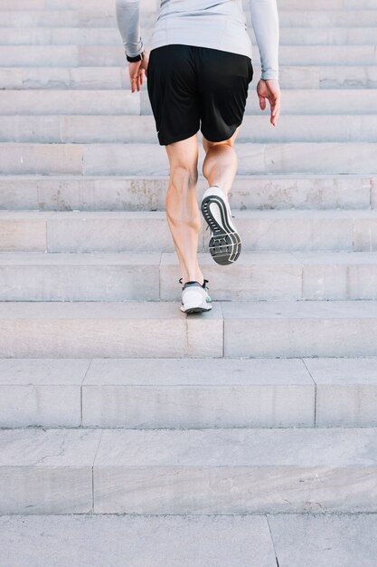 Crop man running on steps