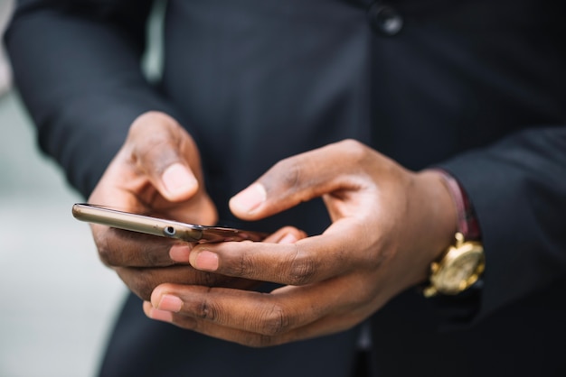 Crop man typing message on smartphone