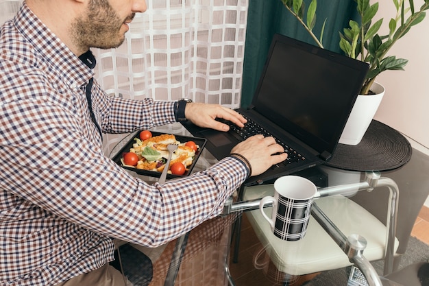 Free Photo crop man using laptop during dinner