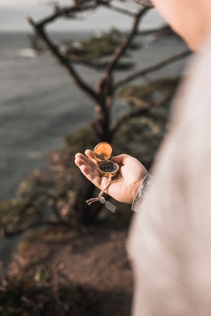 Free photo crop man with compass on cliff